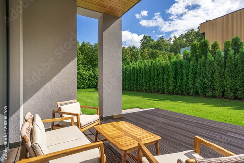 Fotografie A small relaxation area features wooden chairs and a table