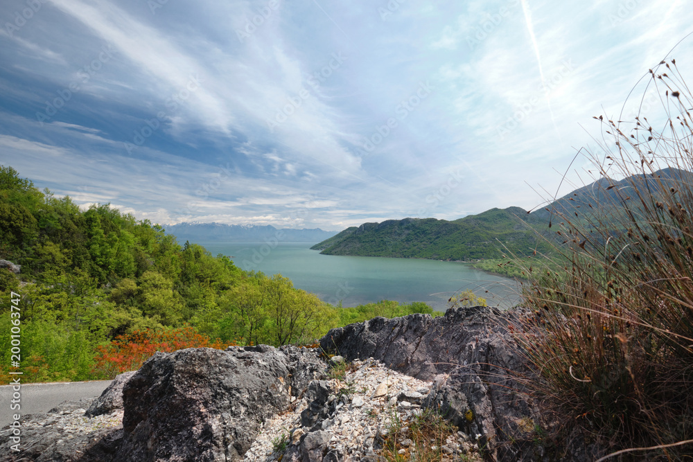 Obraz premium Skadar Lake Rumija mountain ridge with spring vegetation and flowing cloud formations