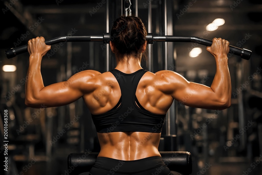 Naklejka premium Muscular woman doing lat pulldown exercise in gym with exercise muscular strength training pulldown bodybuilding athletic lifestyle determined