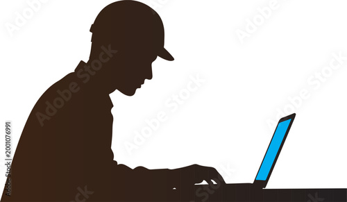 Silhouette profile of male engineer working on laptop at desk space.