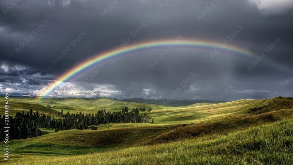 Naklejka premium Dramatic Rainbow Over Rolling Green Hills