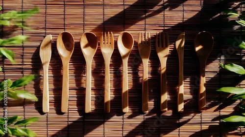 Wooden cutlery set arranged on woven surface with natural sunlight