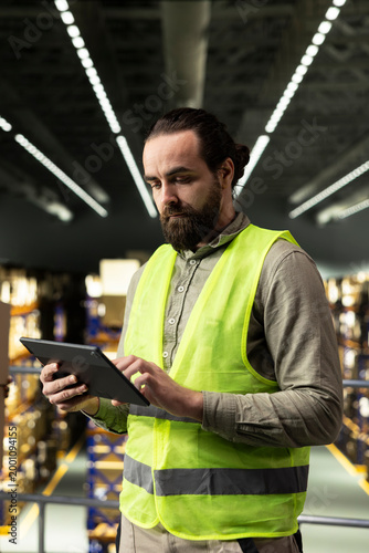Foto Adult man, delivery planning, wearing safety vest, storage warehouse, representing productivity and operational efficiency