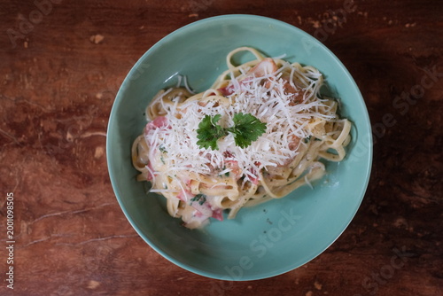 homemade fettuccine alfredo with parmesan and parsley on turquoise plate