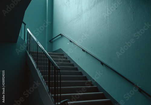 Ascending an interior staircase with teal walls and a metal railing
