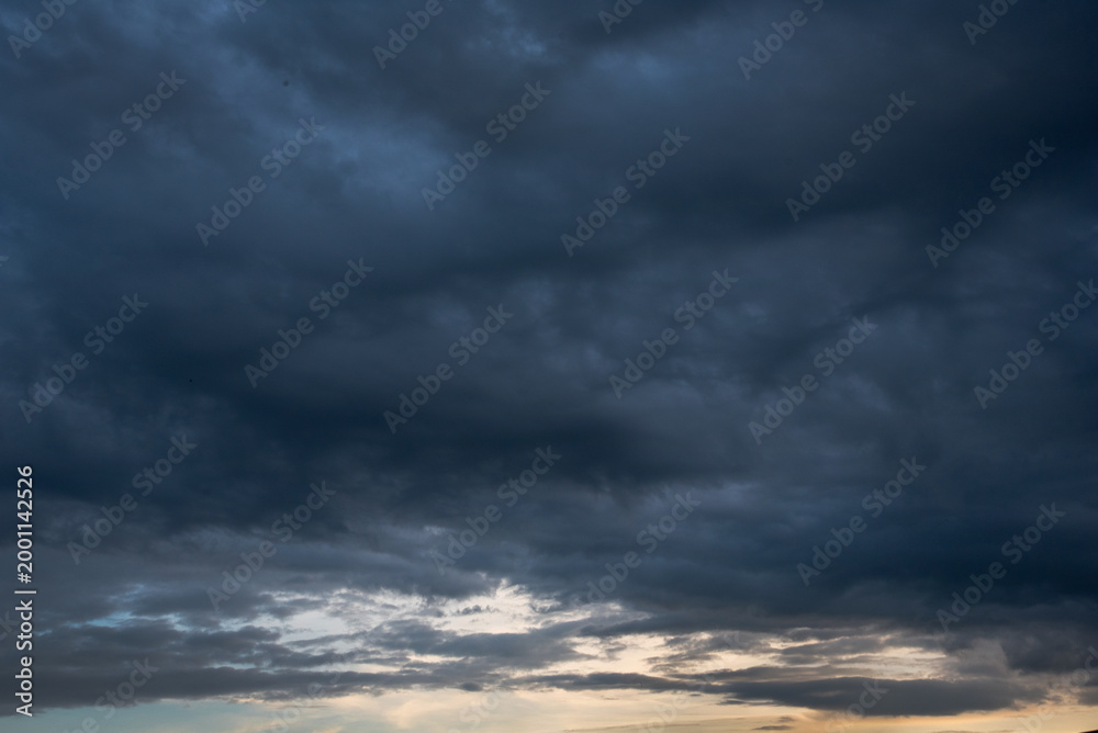Obraz premium Dark thunderstorm clouds rainny season. Meteorology danger windstorm disasters climate. Banner Dramatic dark storm clouds black sky background. Dark thunderstorm clouds rainny atmosphere.
