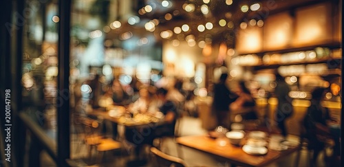 Cozy restaurant interior with warm lighting and blurred patrons dining and conversing