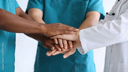 Diverse Medical Team Stacking Hands Together in Hospital Setting