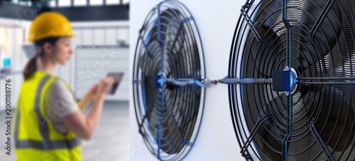 Industrial ventilation maintenance, engineer inspects cooling fans using tablet, airflow control, equipment monitoring and climate system diagnostics in facility