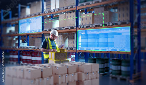 Photos Warehouse worker using a tablet to manage inventory with digital tracking system