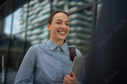Foto Young businesswoman smiling holding tablet discussing project