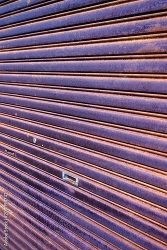 A metal garage roll up door in a rusty condition