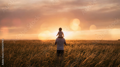 Sunset silhouette of father and child bonding in golden hour light.