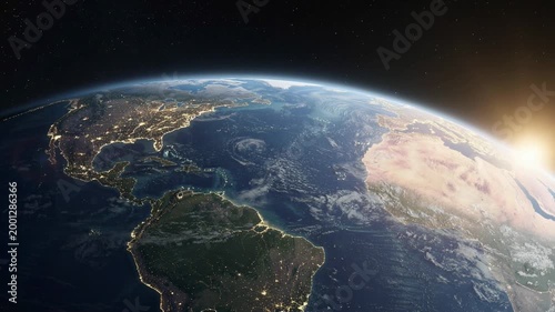 Stunning view of Earth from space showing North and South America with city lights and sunrise over the horizon