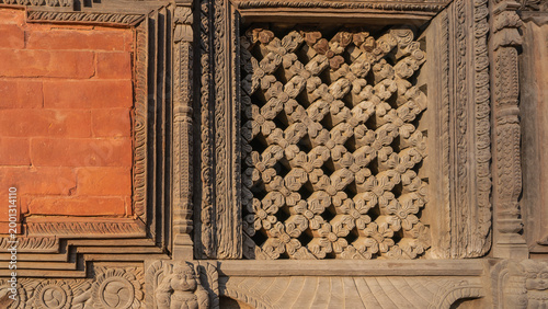 The famous Newar architecture. Details. The facade of a stone brick building. A barred window. Exquisite wood carvings. Nepal. Kathmandu. Durbar Square.