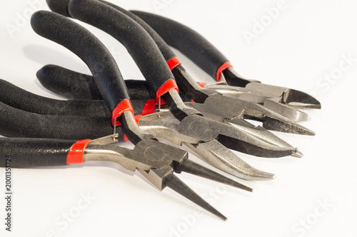 Foto Set of different types of pliers and side cutters isolated on black background
