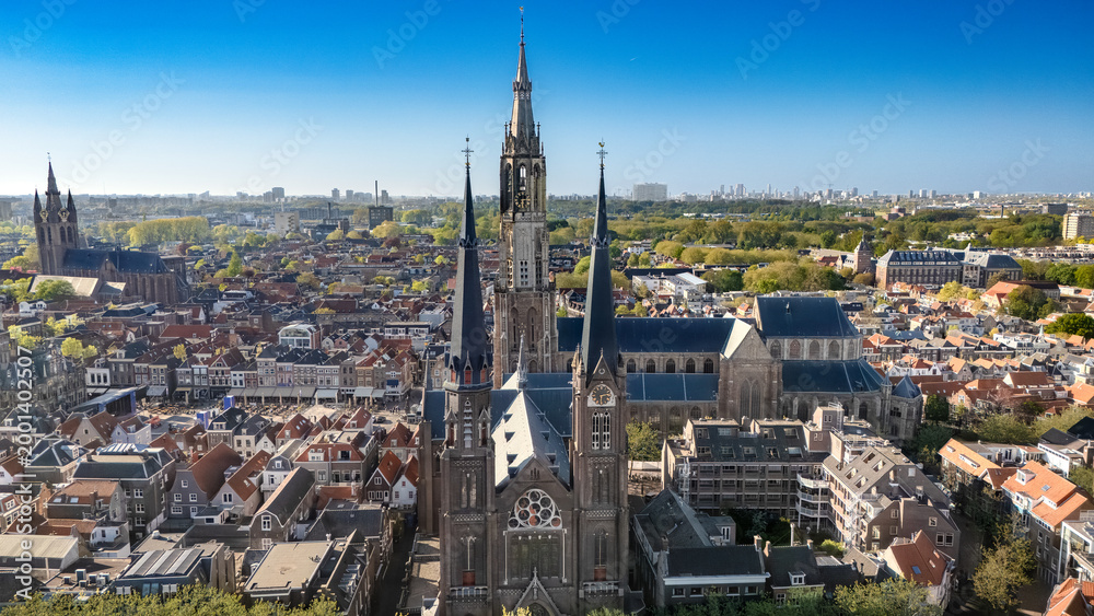 Obraz premium Aerial drone view of Delft with historic cathedrals, panoramic cityscape of old town Delft with traditional Dutch architecture, market square and city center, the Netherlands