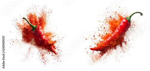 Two vibrant red chili peppers exploding into burst of spicy powder showcasing dynamic motion and bold colors against clean isolated on a white or transparent background