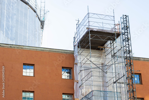 Tableau sur toile Construction scaffolding on a building exterior with a partially covered wall an