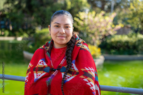 Peruvian woman wearing traditional poncho and smiling while enjoying outdoors
