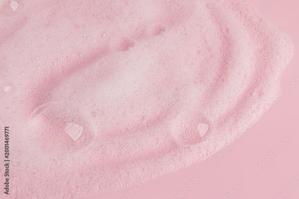 Fototapeta premium Whipped soap dense foam with bubbles on pink background . Cosmetic background. Copy of the space. Layout for the presentation of a spa product.