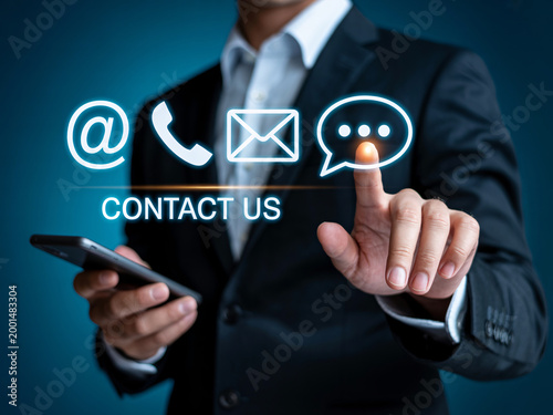 A businessman in a suit interacts with a digital contact us interface on a mobile phone