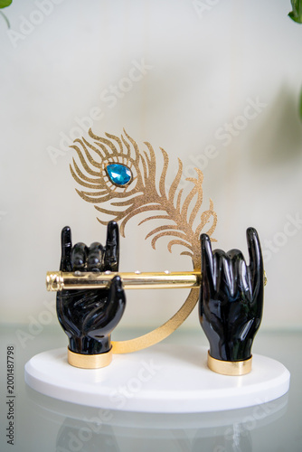 made up statue krishna hands and flute with peacock feather 