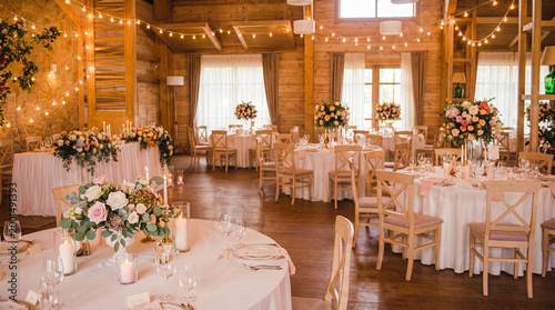 Fotografie Beautifully decorated wedding reception hall with multiple tables, floral arrangements, and string lights
