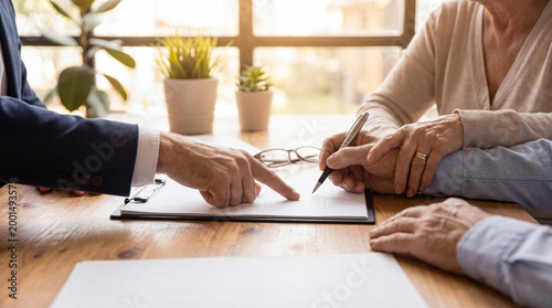 Bild auf Leinwand Elderly couple signing legal documents with a lawyer's assistance, emphasizing trust and crucial financial decisions