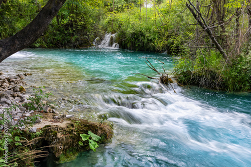 Valokuva Scenic Plitvice lakes turquoise river flows dense with small cascades mossy rocks dynamic motion serene atmosphere