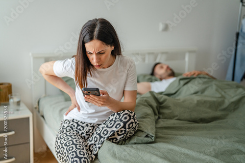 Εκτύπωση καμβά Woman finding evidence of mistrust on phone while man sleeps