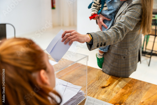 Cuadro en lienzo Woman holding child casting vote in ballot box