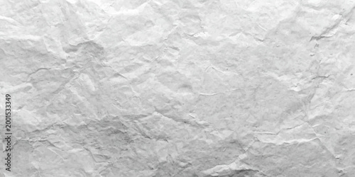 A vintage blank white sheet of crumpled paper displays a rough creased texture and wrinkled grunge pattern, creating a crushed material surface perfect for a textured design background