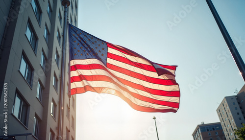 American flag waving at half-mast in urban morning light, honor