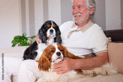 Fotografía Senior Man Relaxing on Couch With Two Cavalier King Charles Spaniels, Bonding an