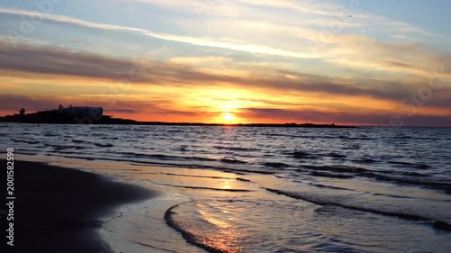 A picturesque sunset with calm waves on the Gulf of Finland in St. Petersburg