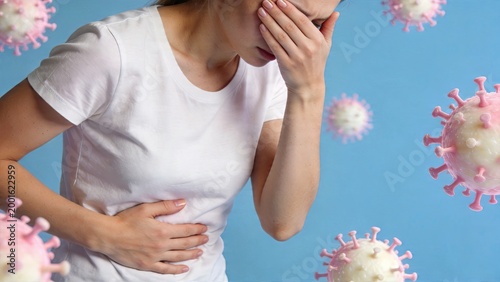 Young adult woman suffering from stomach pain holding abdomen covering eyes with hand feeling sick unwell nausea vomiting illness virus infection concept with floating pathogen