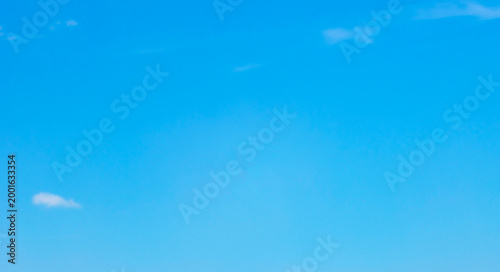 Fotografie Minimalist background of a clear blue sky with soft thin white clouds on a bright sunny day