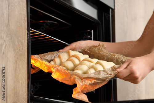 Female baker putting baking...