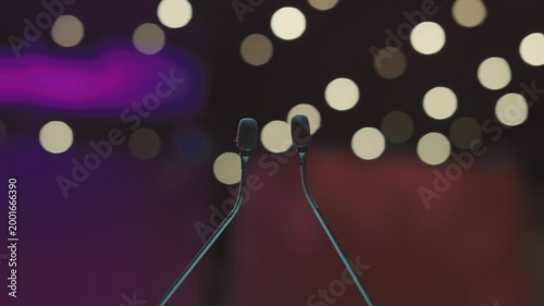 Dual Conference Microphones on Podium with Blurred Audience Background