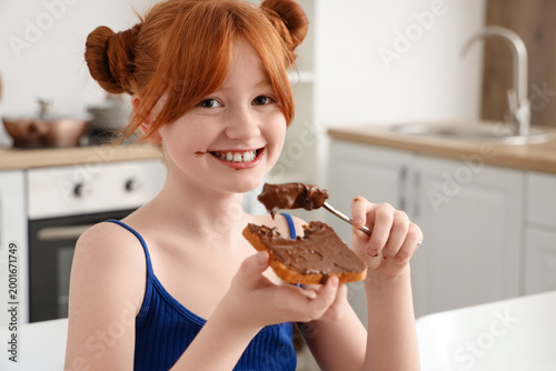 Cute girl eating toast with...