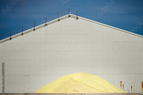Yellow sulfur pile in industrial building storage facility