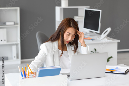 Tired Asian businesswoman w...