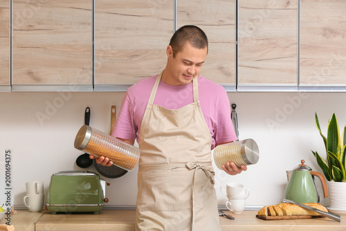 Young man in apron with jar...