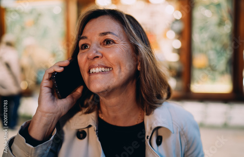 Tableau sur toile Close up happy woman talking smartphone outdoor, smiling Caucasian lady calling