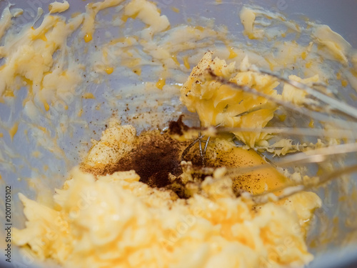 Melted butter and vanilla bean powder combine to create a rich mixture for baking cookies. This simple step adds flavor and warmth to your favorite treat.
