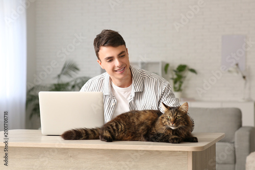 Young man using laptop at t...