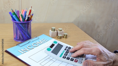 Reddito, una sola parola sul foglio e spazio per la copia, lavoro d'ufficio con calcolatrice
