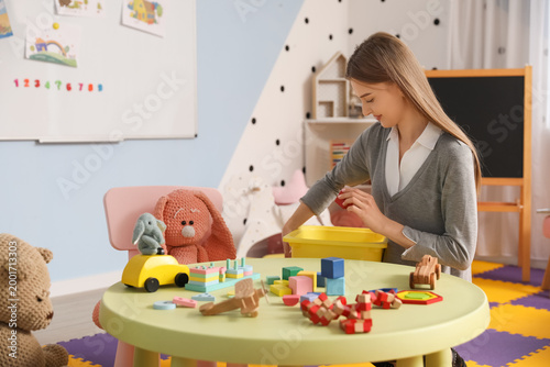 Female nursery teacher putt...