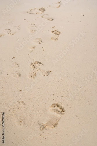 Fotografie Footprints in the Sand: Bare footprints etched into the sand, conveying a sense of journey, exploration, and the ephemeral nature of time, evoking feelings of serenity and solitude